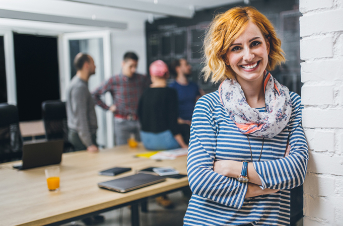 Employee smiling with group of employees in the background