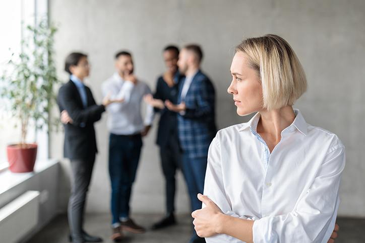 A woman excluded from a conversation between a group of men