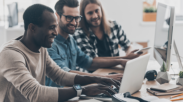 Employees laughing about contents of a laptop