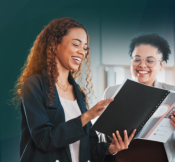 female coworkers reviewing employee handbook