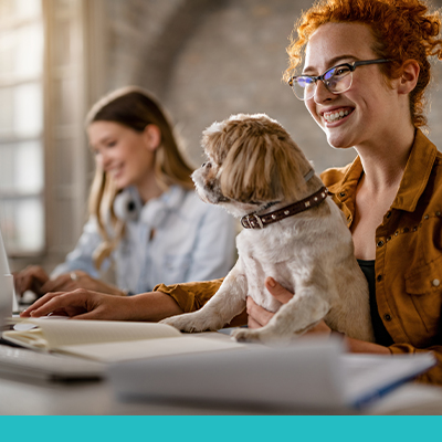 Attractive female with dog on her desk