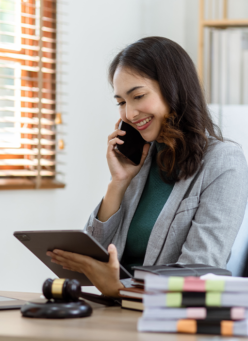 Services - Compliance - Female on the phone looking at a tablet